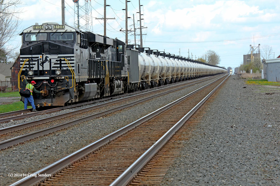 As a crew member adjusts the front coupler of the lead unit, the headline of the westbound stack train that will pick him up is visible in the distance on Track No. 1.