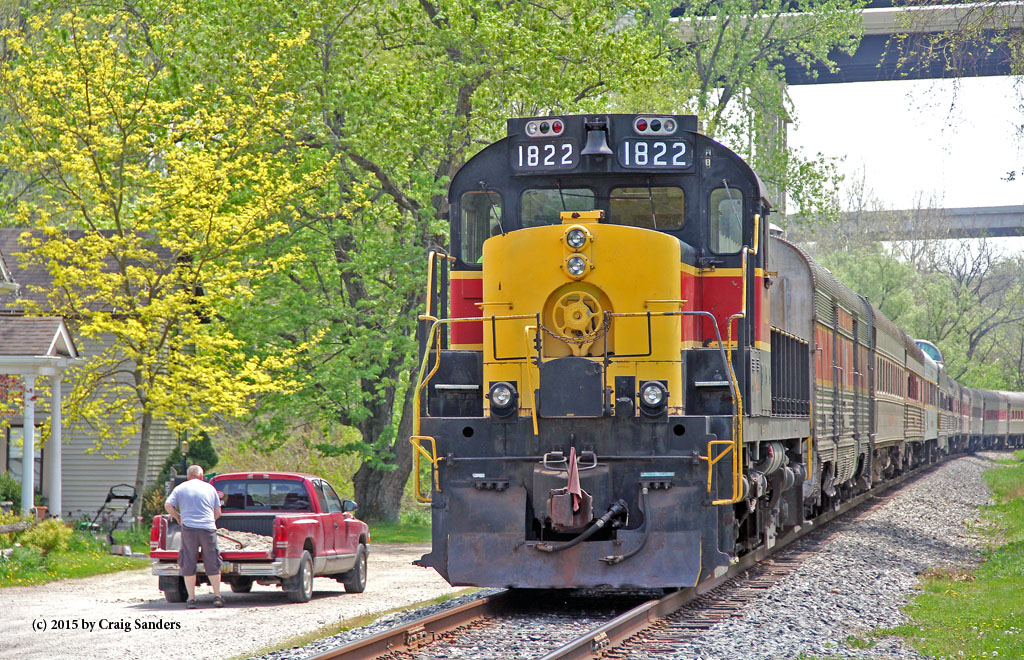 A man goes about his Saturday chores as the southbound Scenic leaves Boston Mill and passes a few  golden flowering trees.