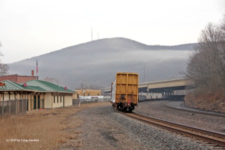 A trace of fog still hovers of the mountains surrounding Tyrone, Pennsylvania, as the last car of an eastbound NS manifest freight is about to pass beneath Interstate 99.