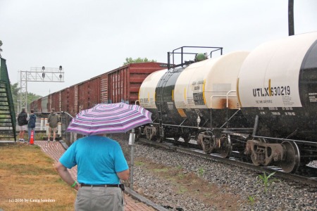 Umbrellas and rain gear was out as an eastbound NS train passes through Marion. 